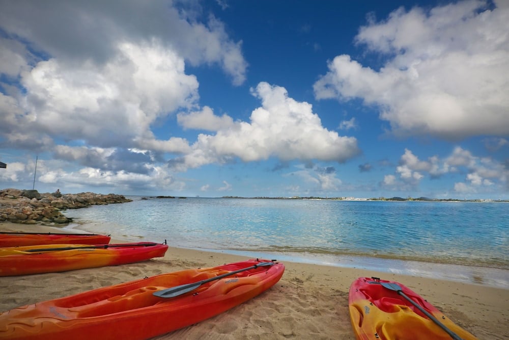 Rode en oranje kajaks op strand aan zee in Sint Maarten