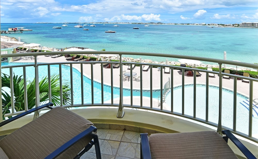 Balkon met uitzicht op zwembad en zee in Sint Maarten