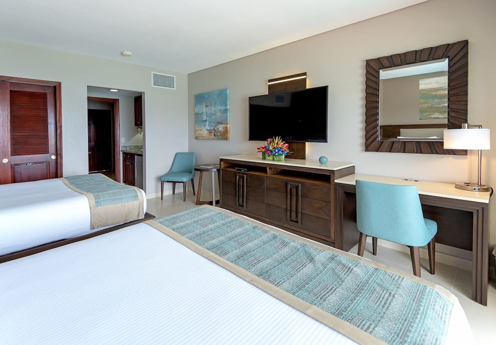 Hotelkamer met bureau, stoelen en tv in Sint Maarten